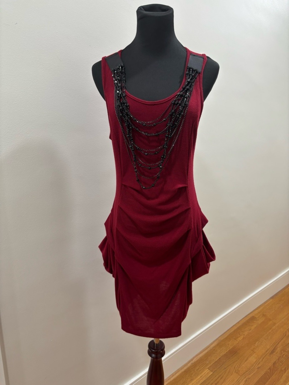 556. Red sleeveless crepe dress featuring a bead-embellished appliqué